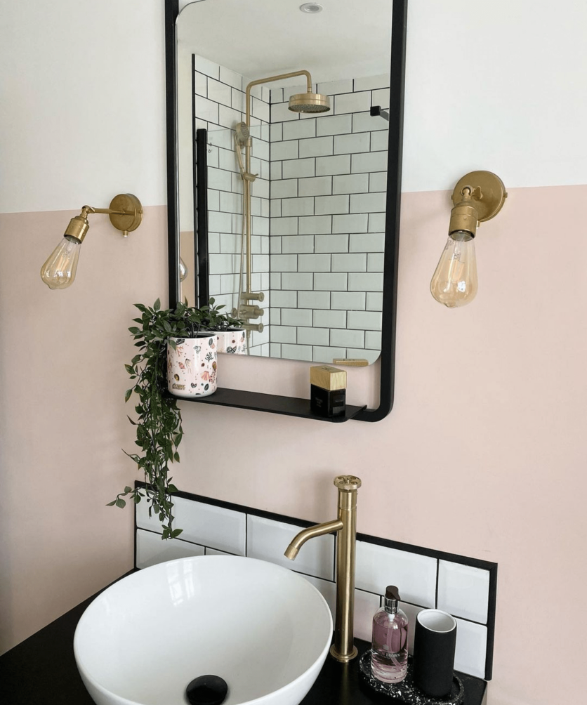 Modern pink bathroom with brushed gold tap, white countertop basin, round exposed gold shower and classic white metro wall tiles.