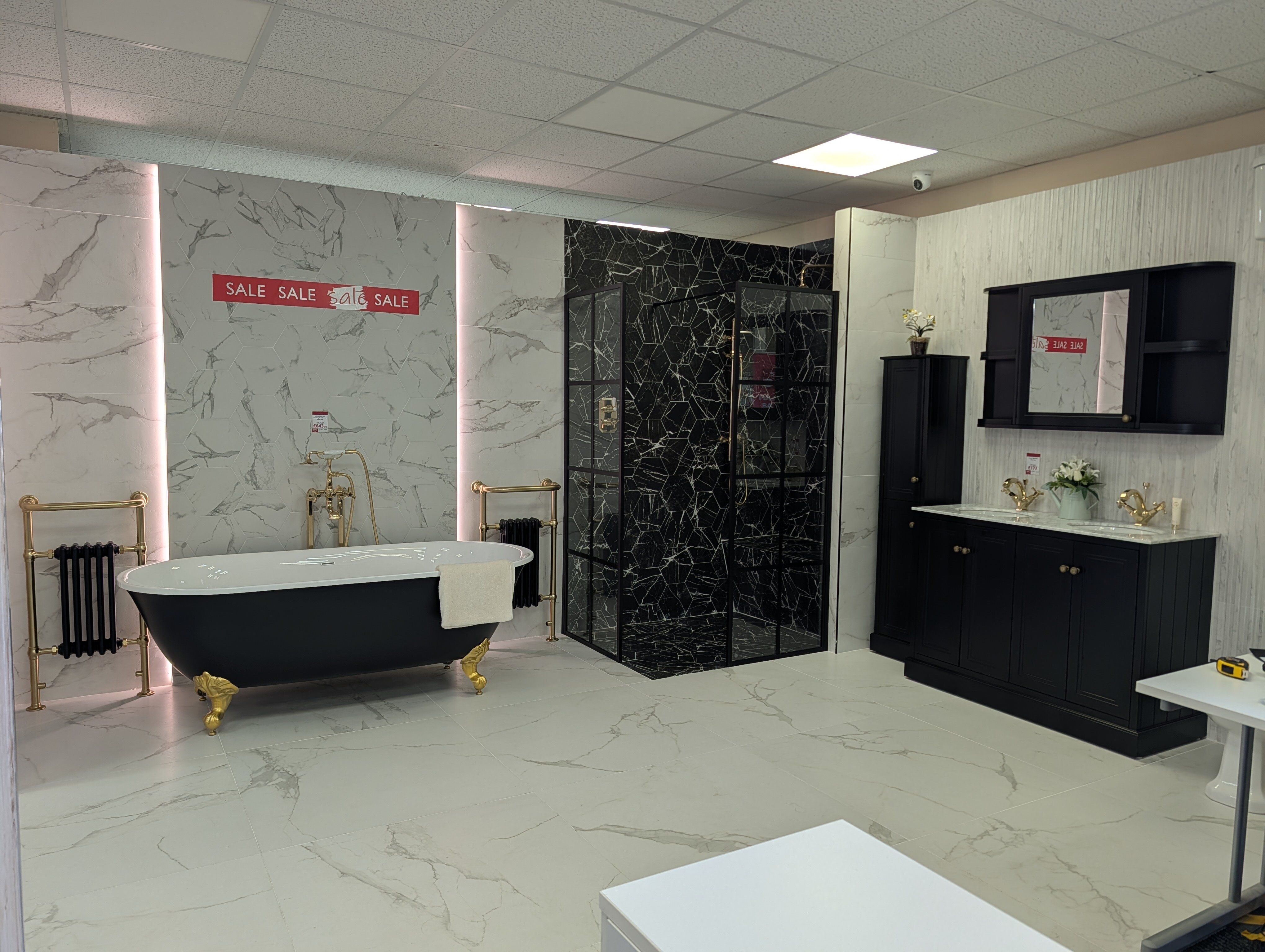 Traditional bathroom display at Easy Bathrooms Fareham featuring black-and-white tiles, dark furniture and gold brassware.
