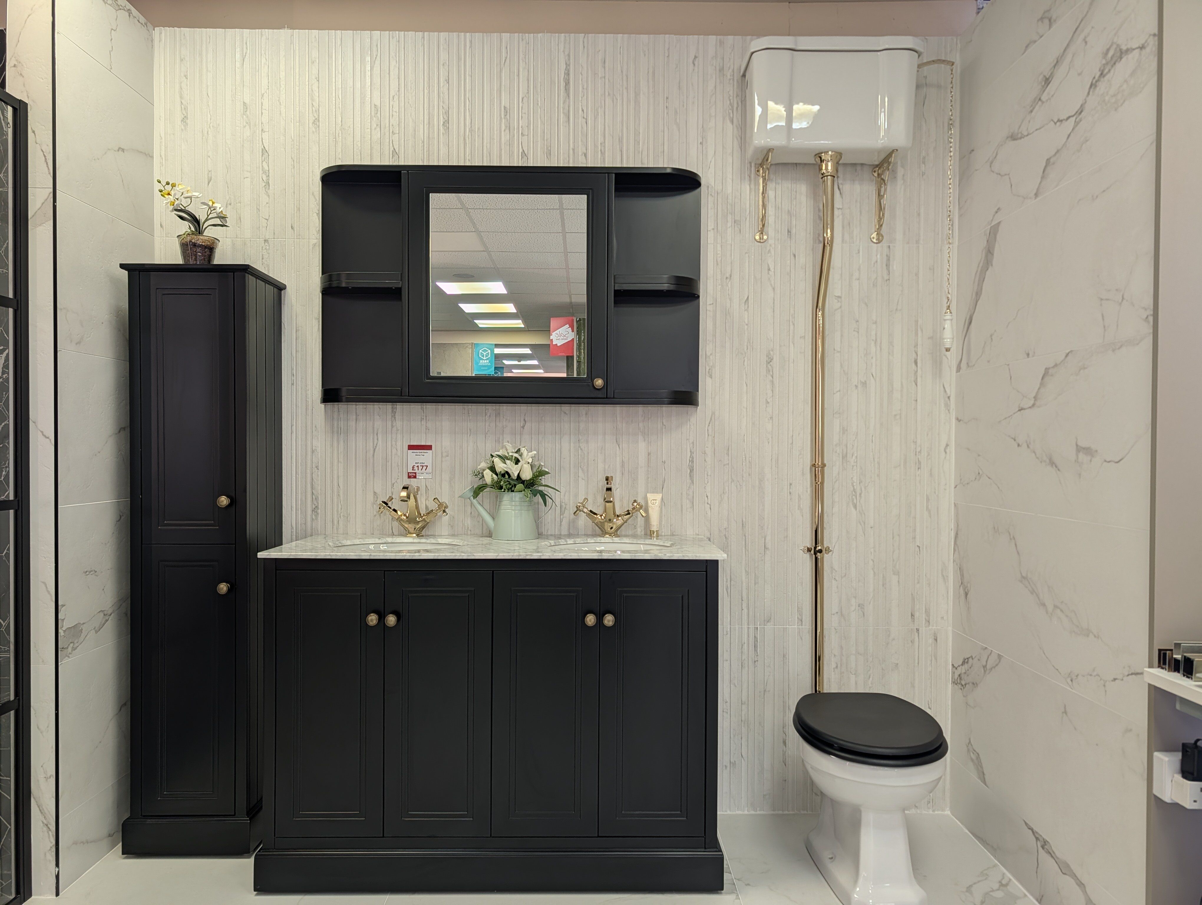 Classic bathroom vanity display at Easy Bathrooms Fareham with dark furniture, mirror and warm gold fittings.