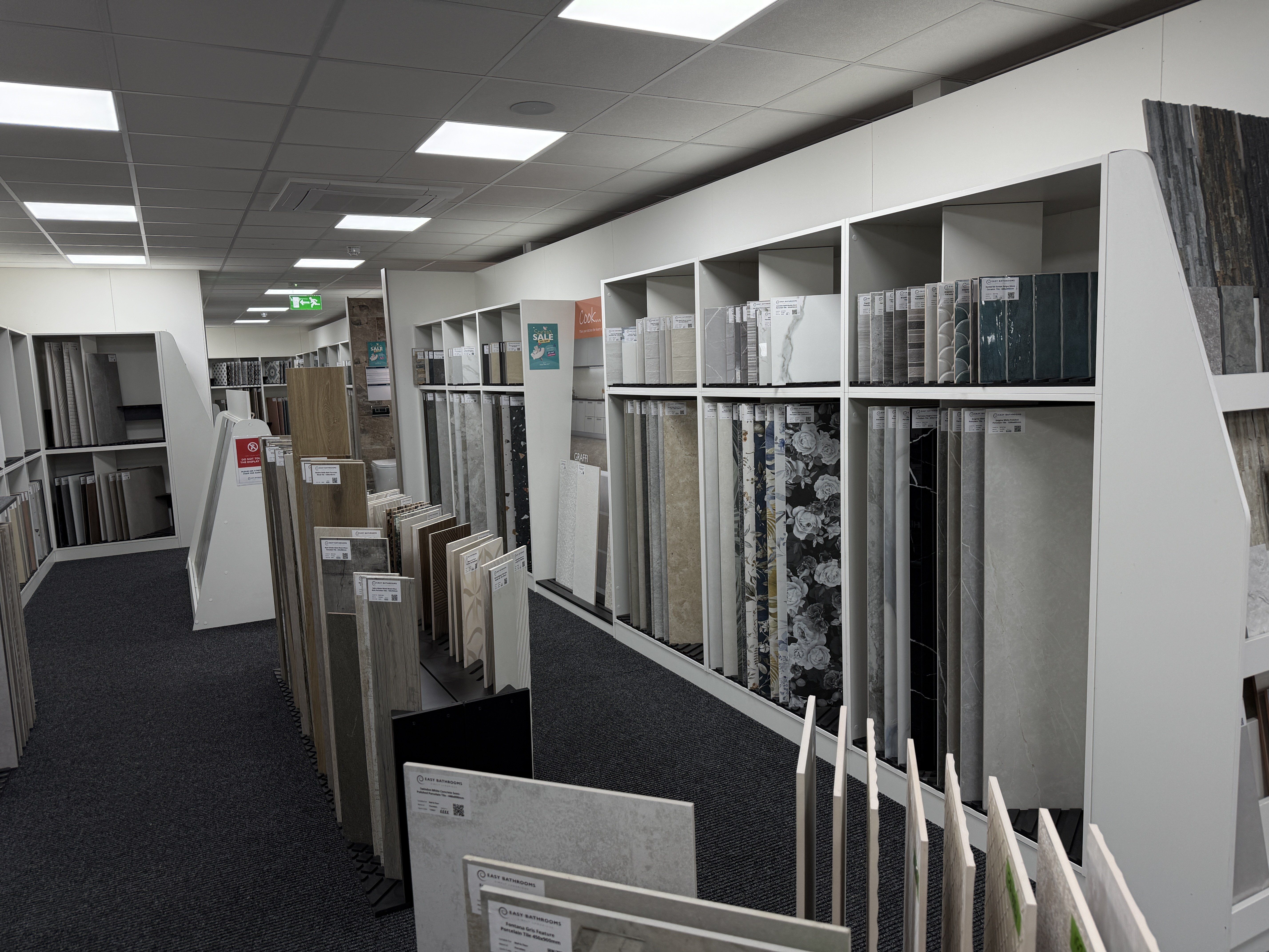 Easy Bathrooms tile showroom with large-format wall and floor tile displays, including marble-effect, stone-effect, wood-effect and patterned designs.