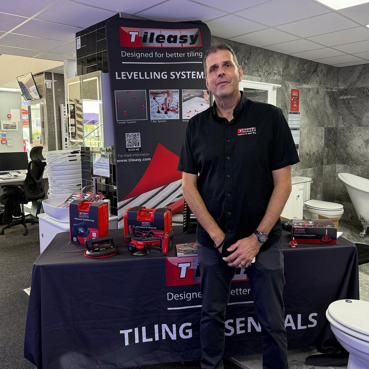 Tileasy representative showcasing tiling tools and levelling systems inside the Easy Bathrooms Aintree showroom