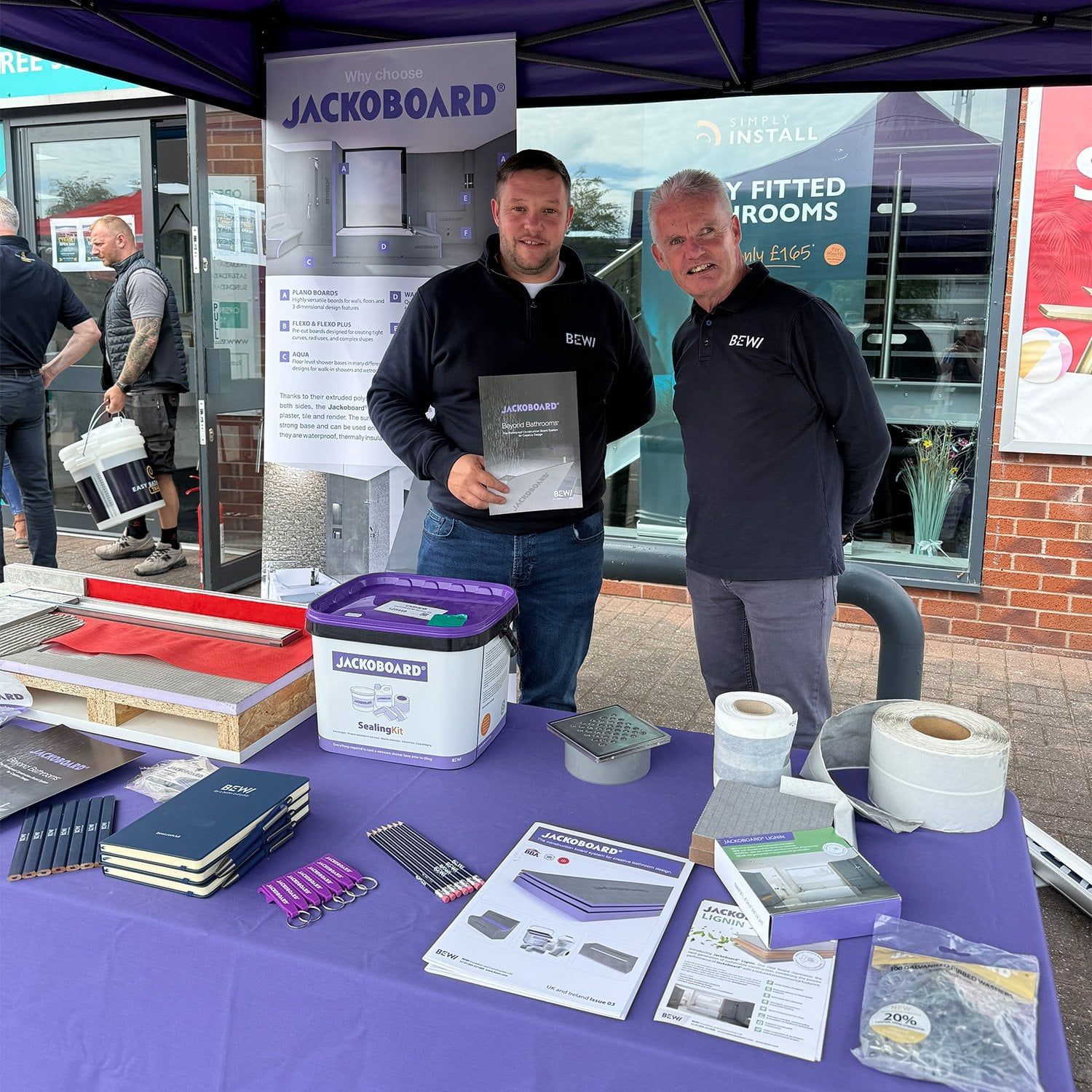 BEWI representatives displaying JACKOBOARD products and bathroom installation materials at the Aintree showroom trade event