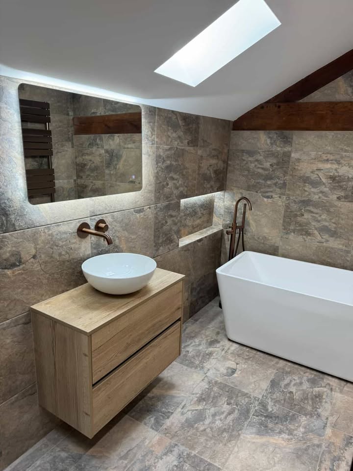 A textured industrial bathroom featuring Fontana stone effect wall tiles and geometric decor tiles, an Urban rustic wood vanity with a Sphere basin, and Taylor brushed nickel fixtures throughout.