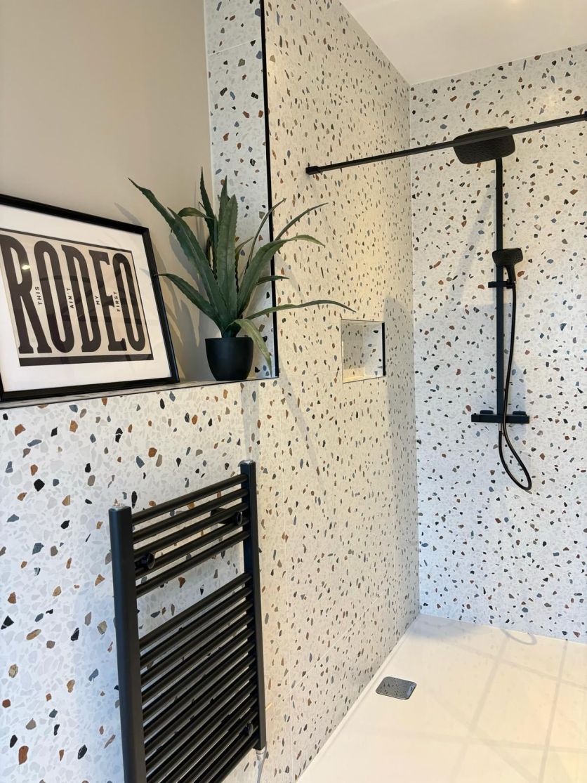 terrazzo style tiles in a modern shower room with black accents