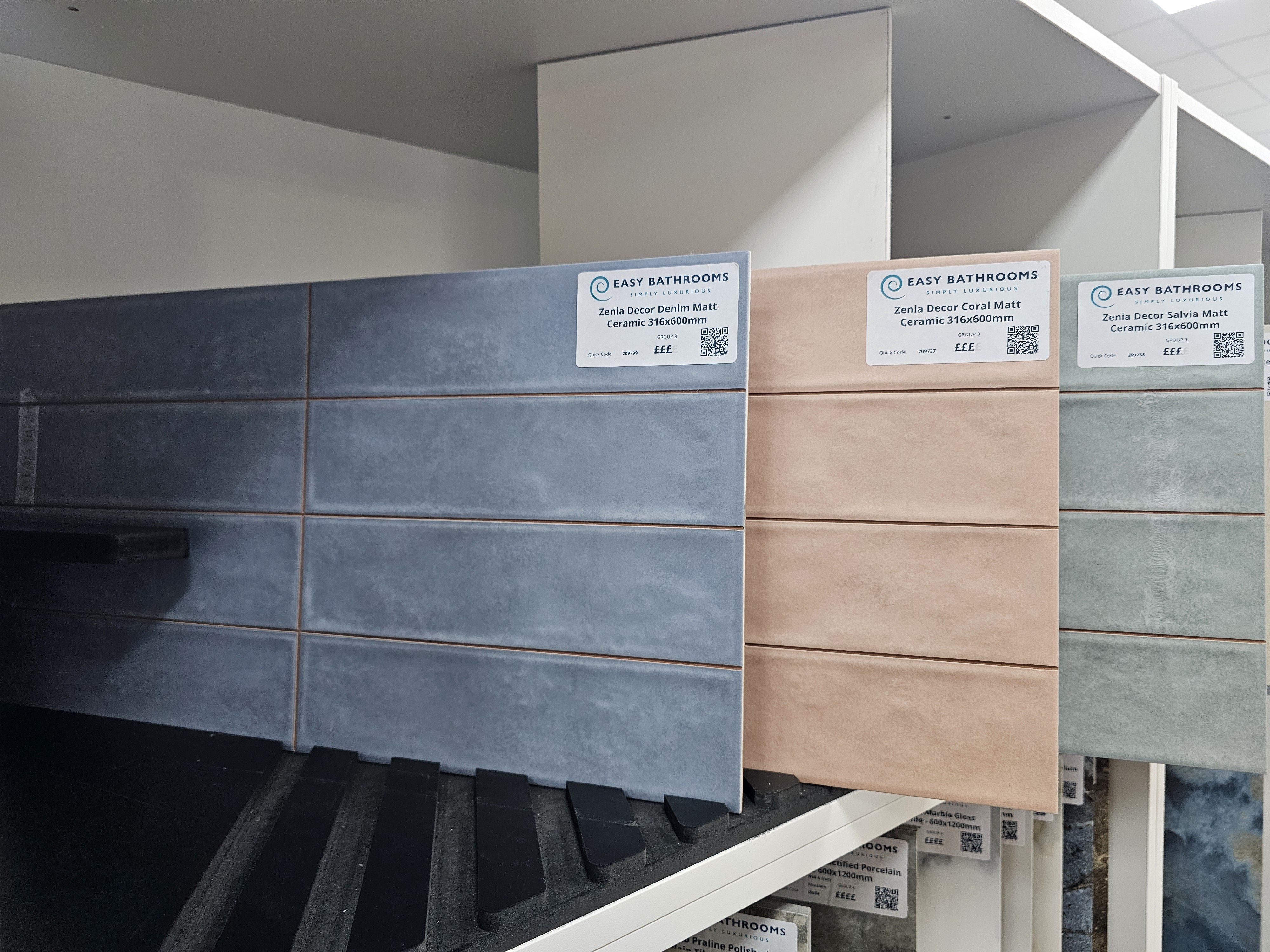 New bathroom tile samples in grey, blue and neutral finishes displayed at the Easy Bathrooms Folkestone showroom.
