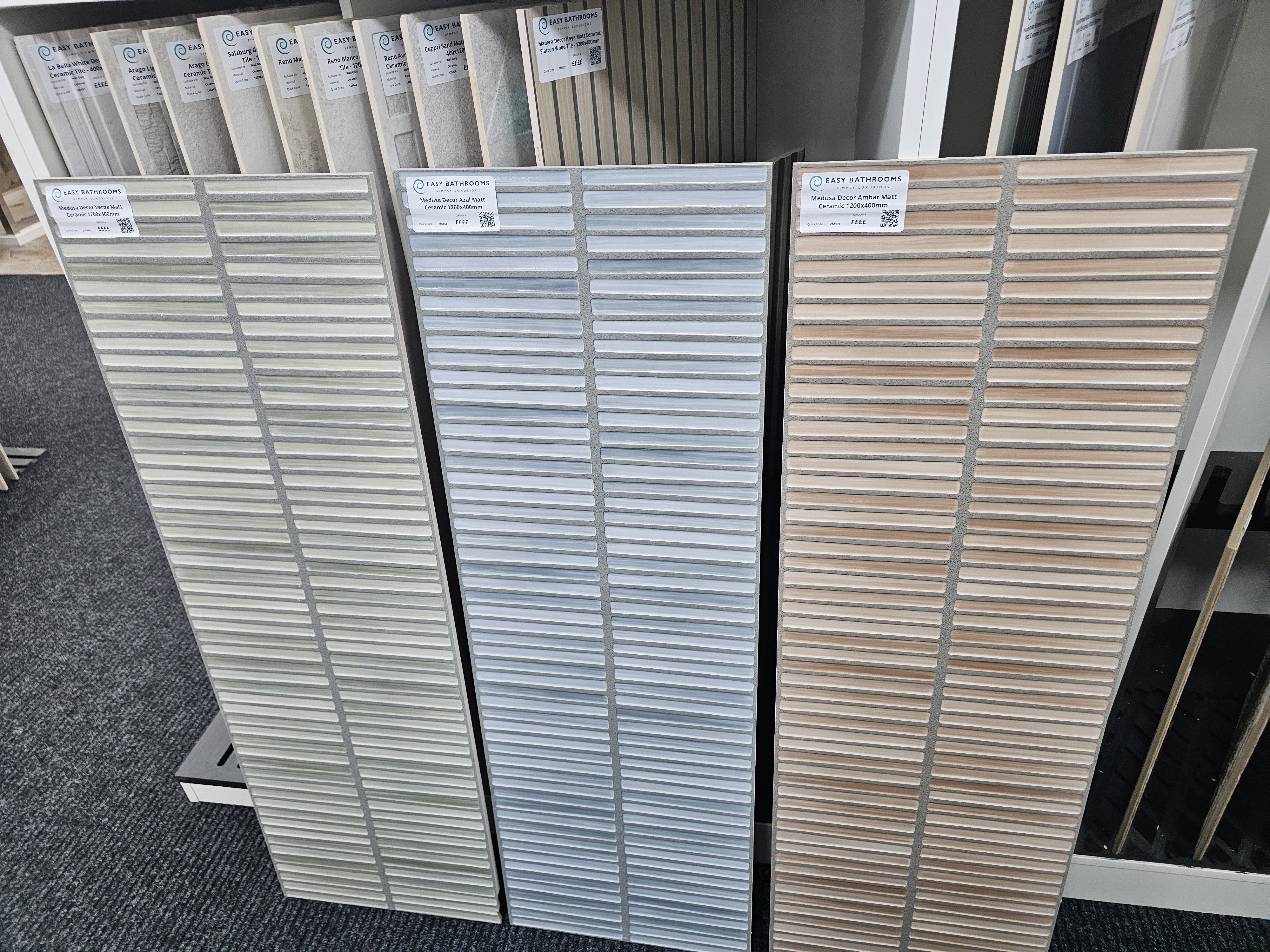 Textured rectangular wall tile samples in soft grey, cream and blush tones.