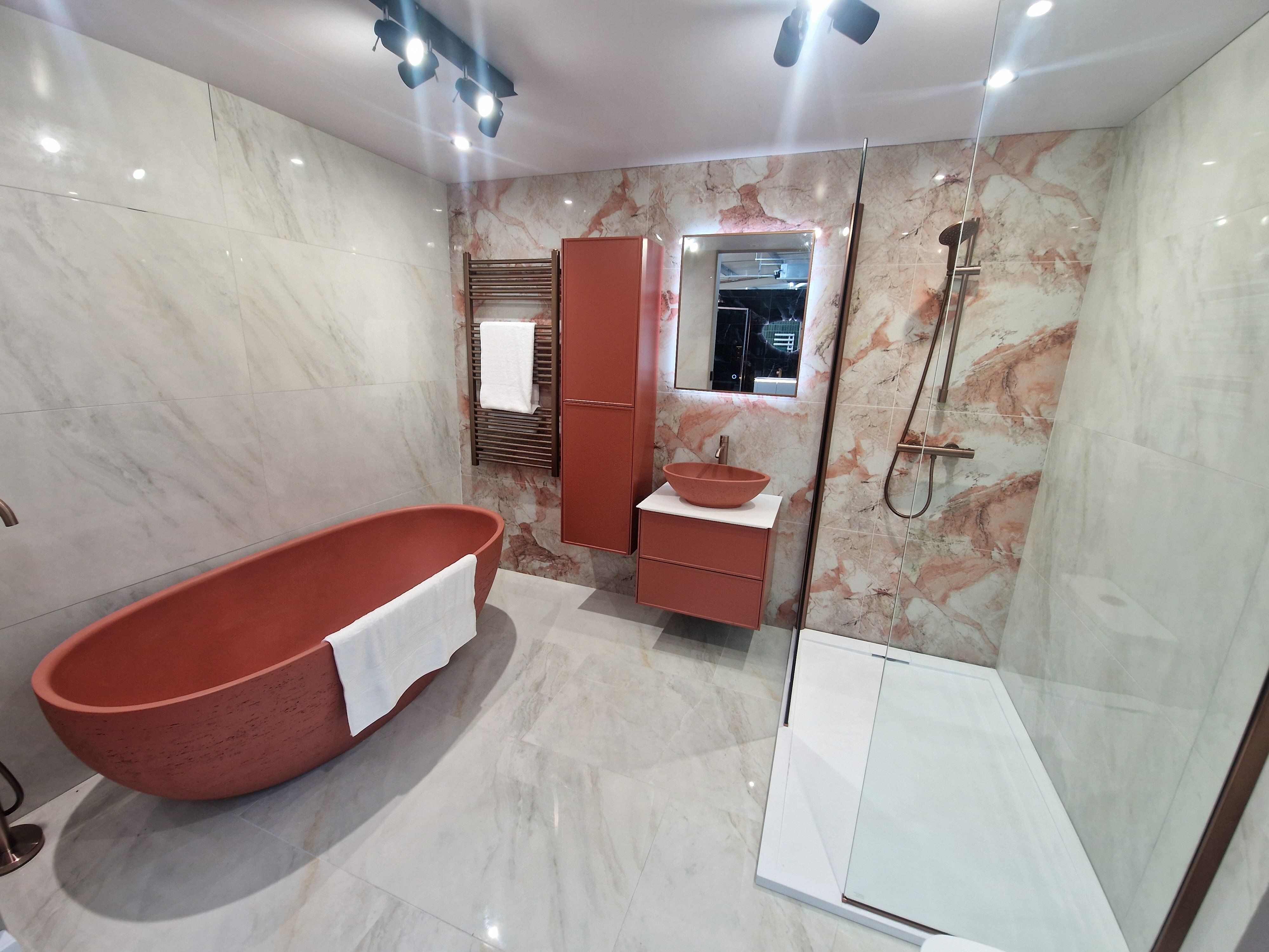 Stone free standing bath in bold terracotta tones at Easy Bathrooms Cirencester