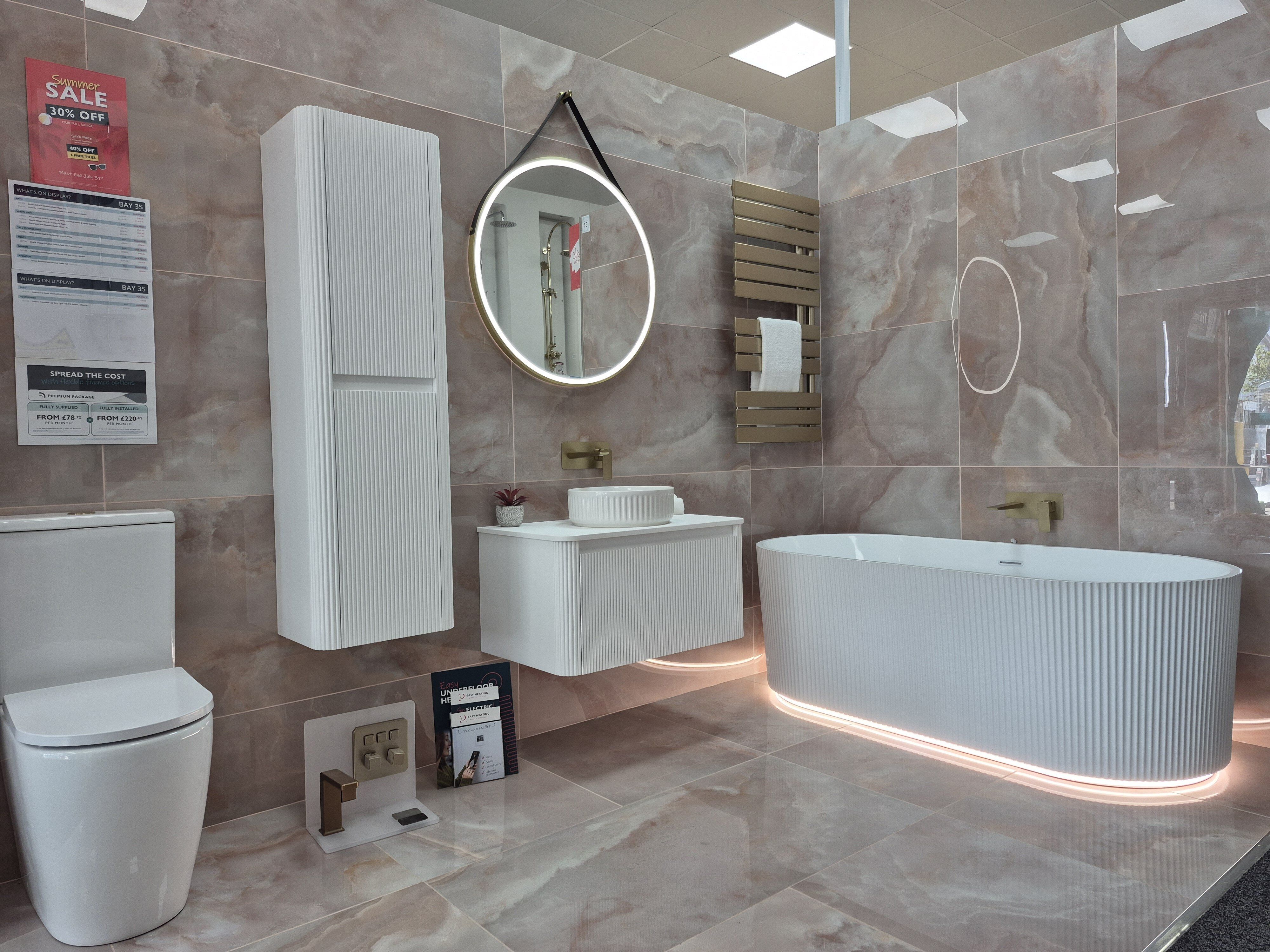 Pink bathroom display at Easy Bathrooms Doncaster featuring Rosa Coral tiles, Wish furniture, a freestanding bath and brushed gold brassware.