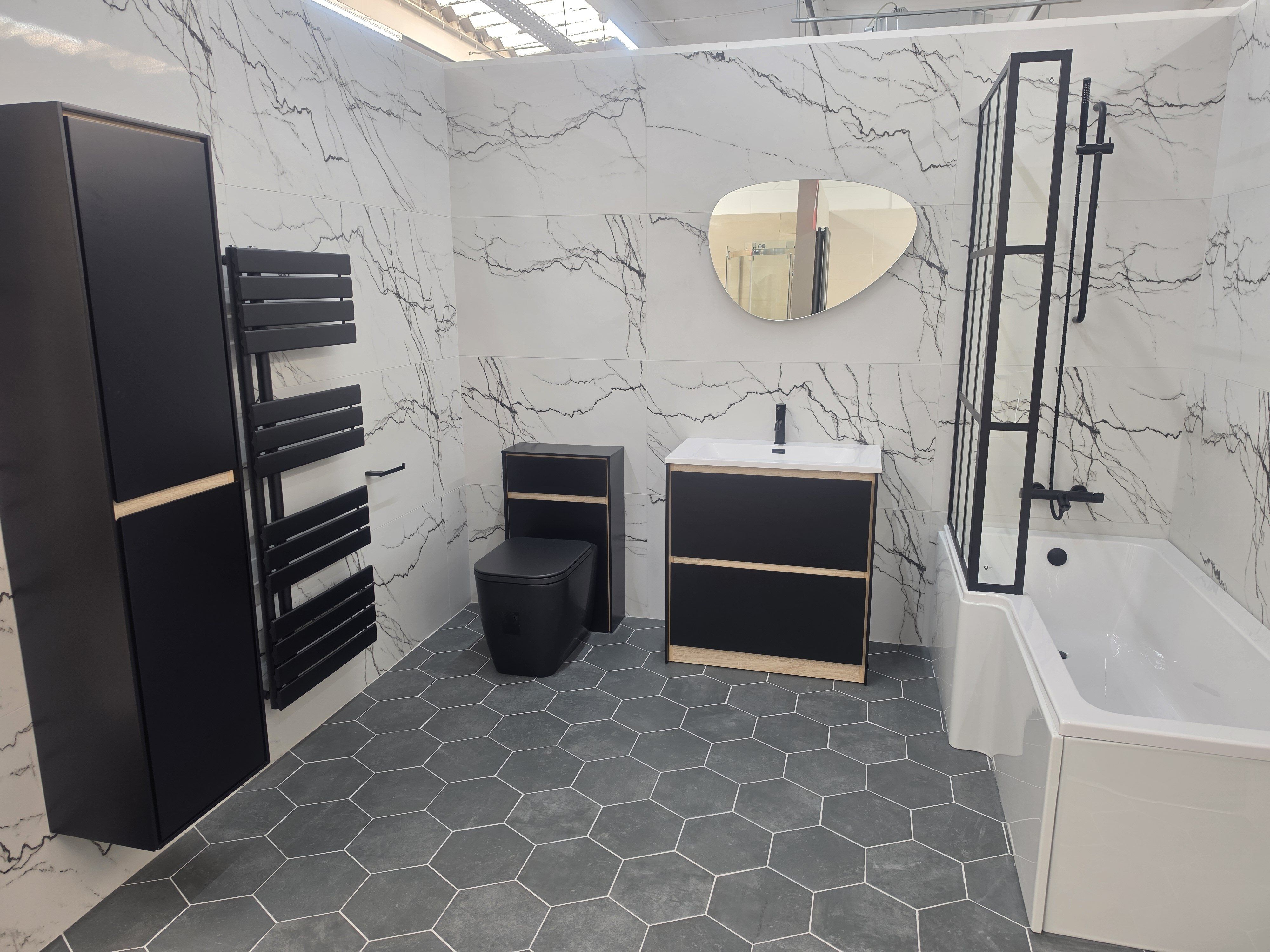 Monochrome bathroom display with black bathroom furniture, designer heated towel rail and floating units