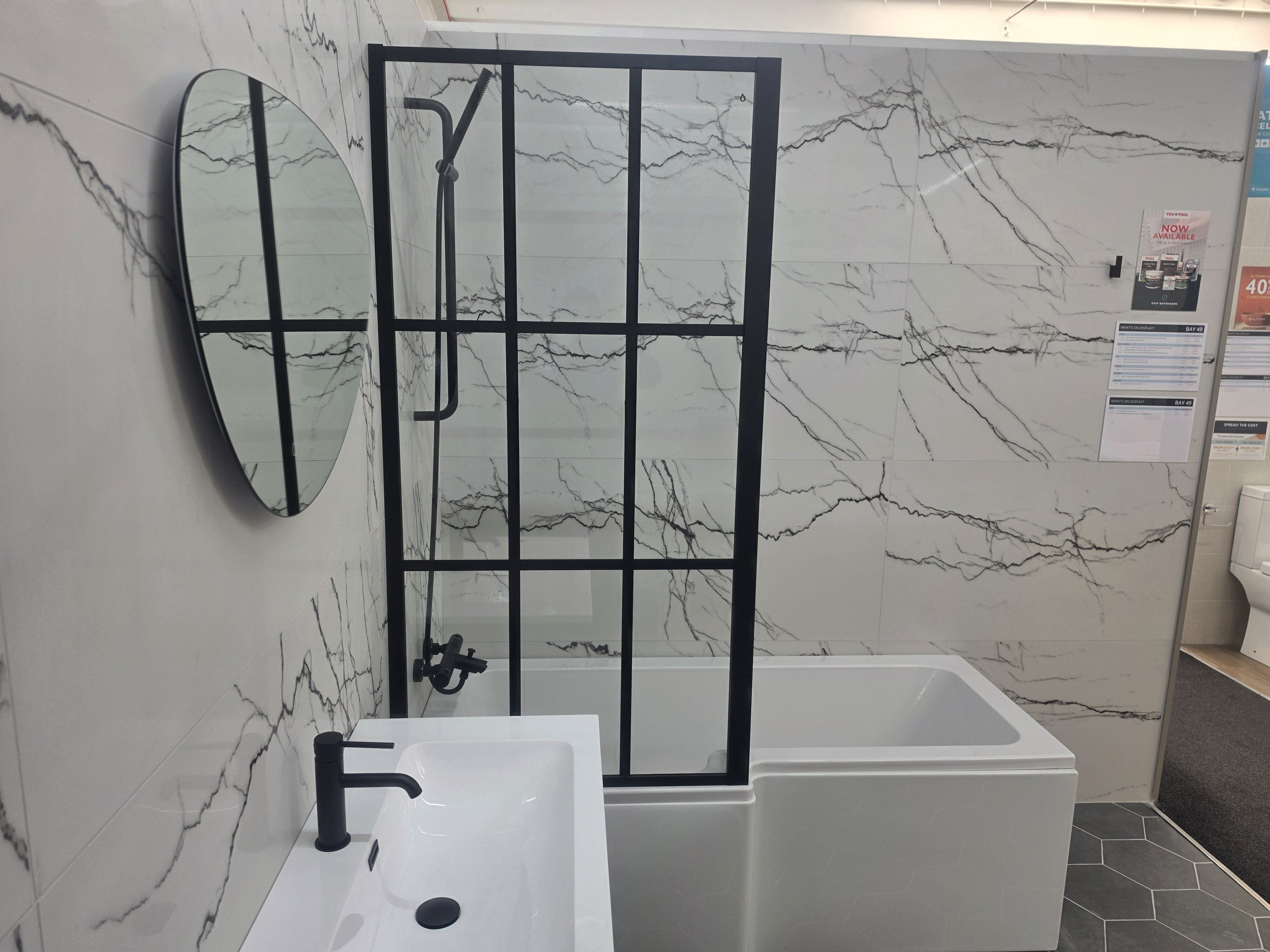 bathroom display featuring modern marble tiles and black framed shower screen