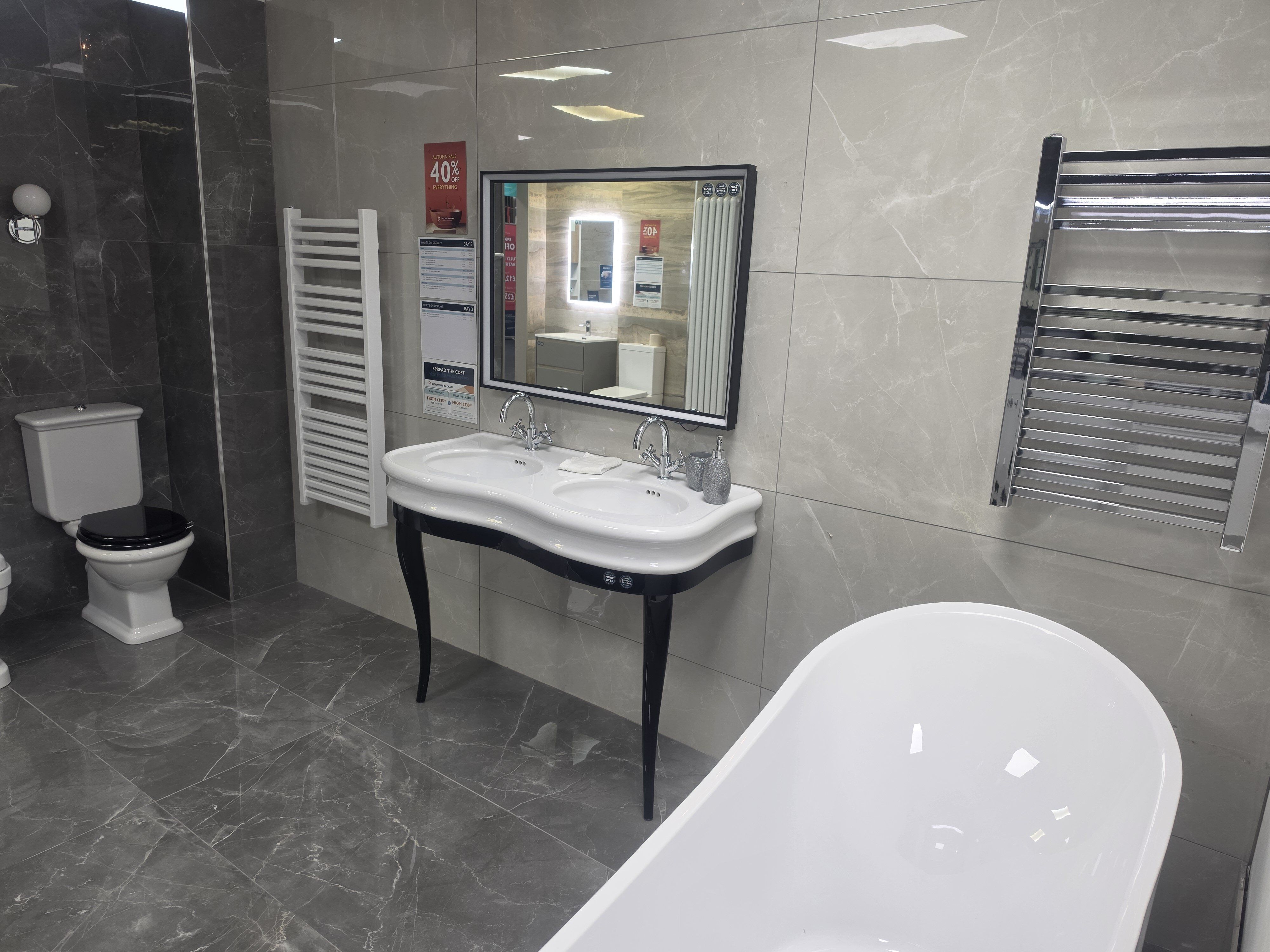 Showroom display featuring traditional bathroom furniture including vanity sink with wood finishes