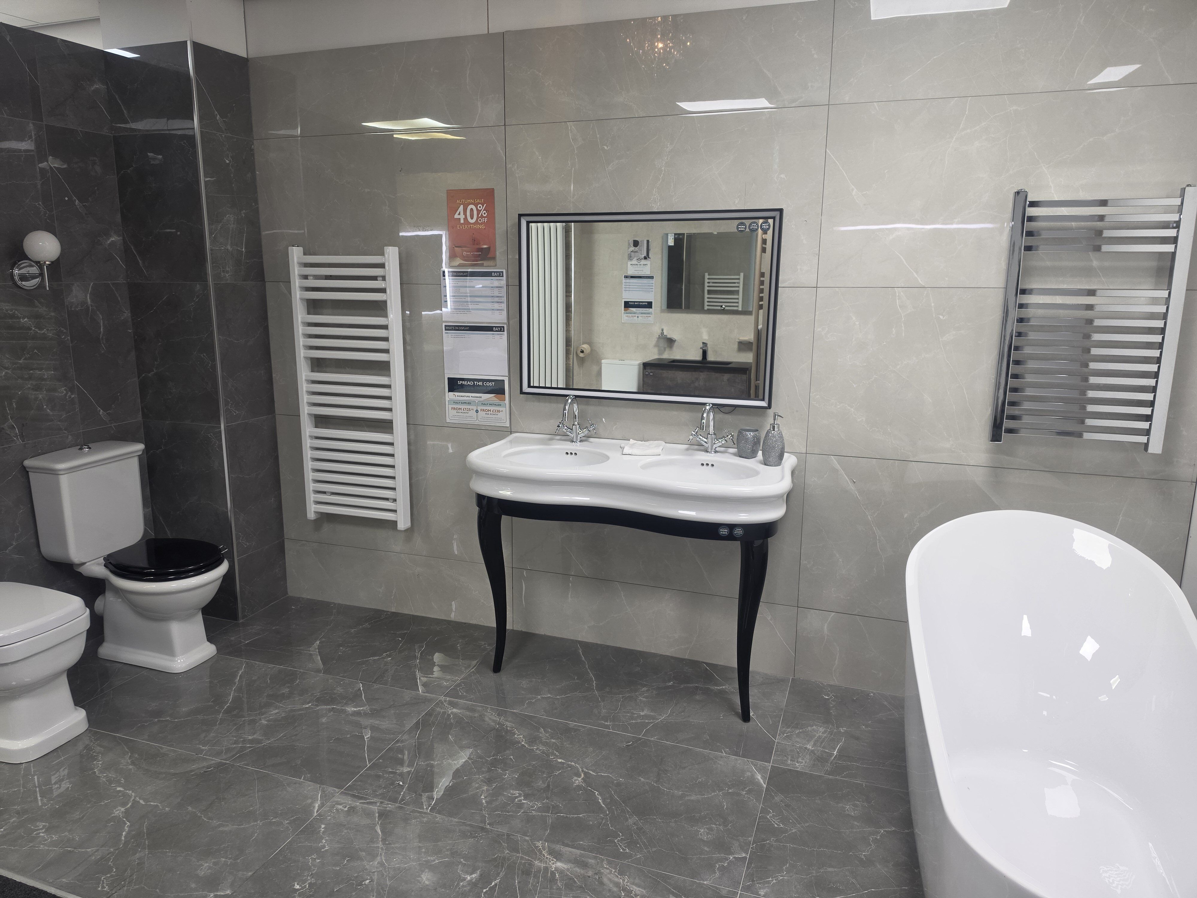 Showroom display featuring classic bathroom furniture including wood finishes and free standing bath