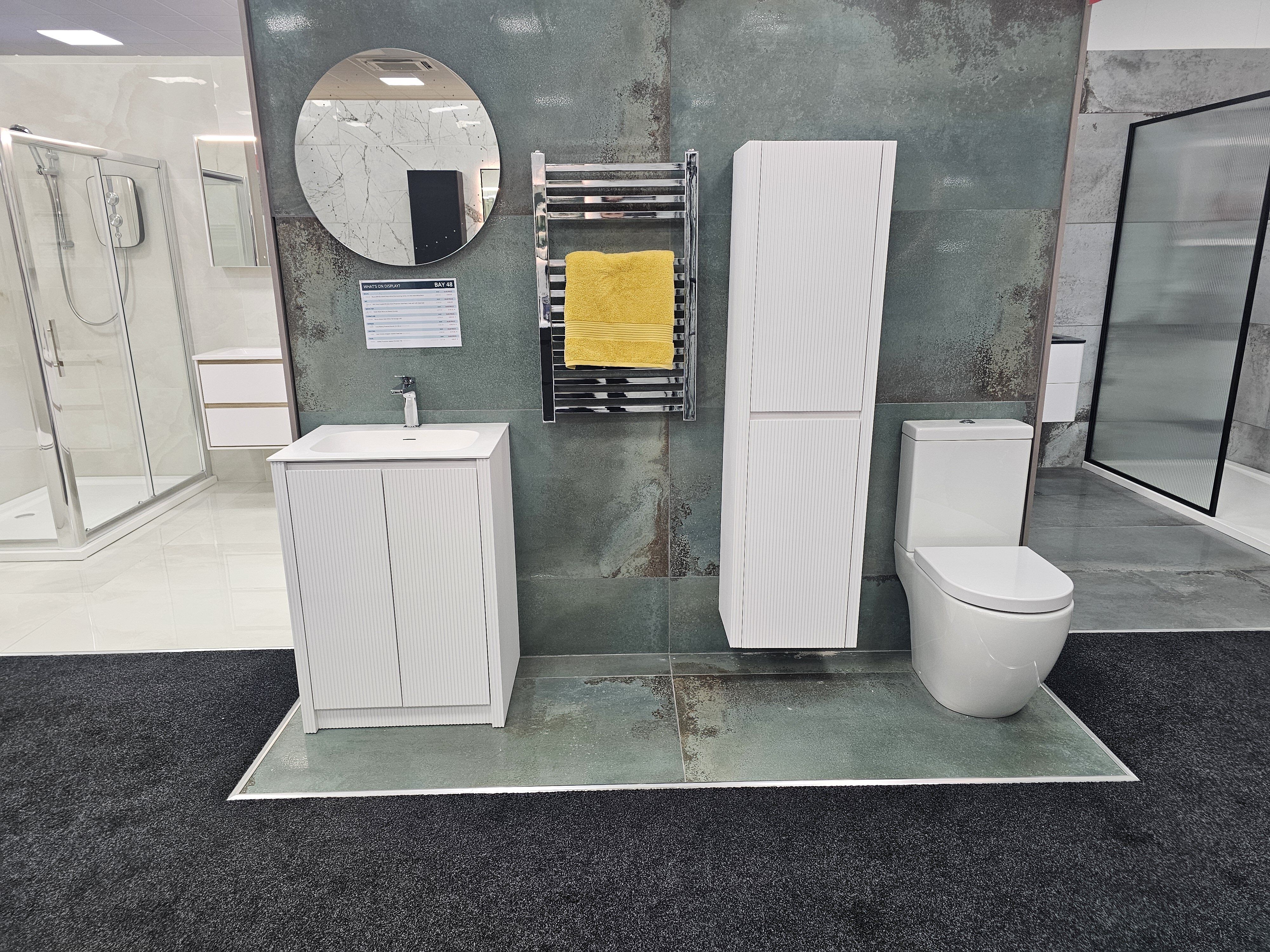 Showroom display featuring bathroom furniture in modern style, paired with distressed industrial tiles