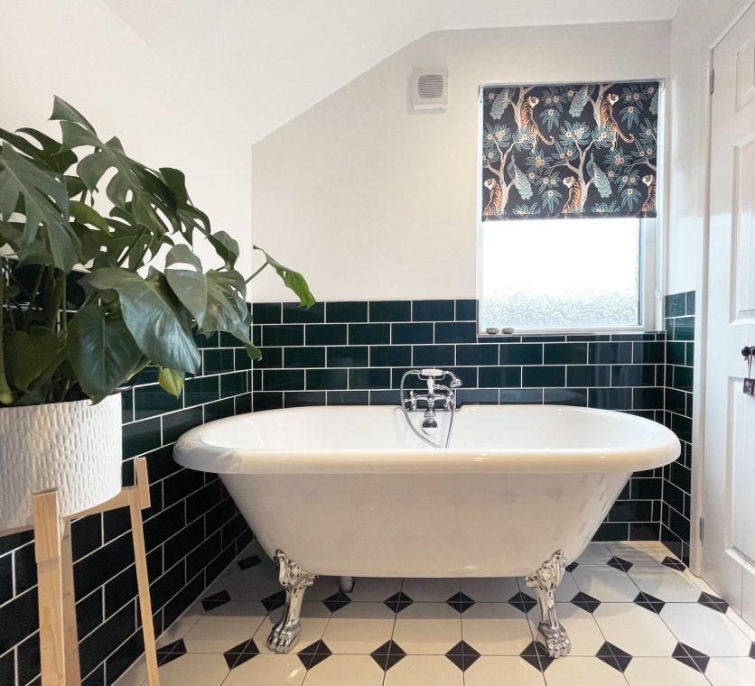 A luxurious white freestanding slipper bath with ornate chrome claw feet, featuring a traditional chrome bath shower mixer tap.