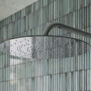Aqualisa S3 Chrome Wall Fixed Shower Head detailed view upon a teal tiled background