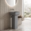 matt grey full pedestal square basin with rounded corners in a neutral modern bathroom with ribbed tiled walls