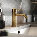 Moray Brushed Gold single lever basin mixer tap featuring a textured knurled detailing - Roomset
