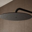 Aqualisa S3 black Wall Fixed Shower Head detailed view upon a brown tiled background
