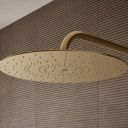 Aqualisa S3 Gold Wall Fixed Shower Head detailed view upon a brown tiled background