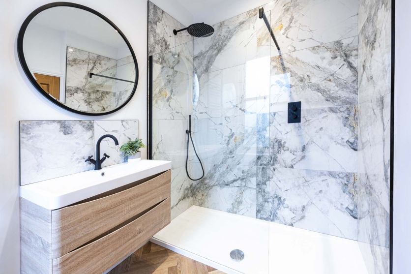 Modern marble bathroom with walk-in shower, matt black rainfall shower head and oak wall-hung vanity.