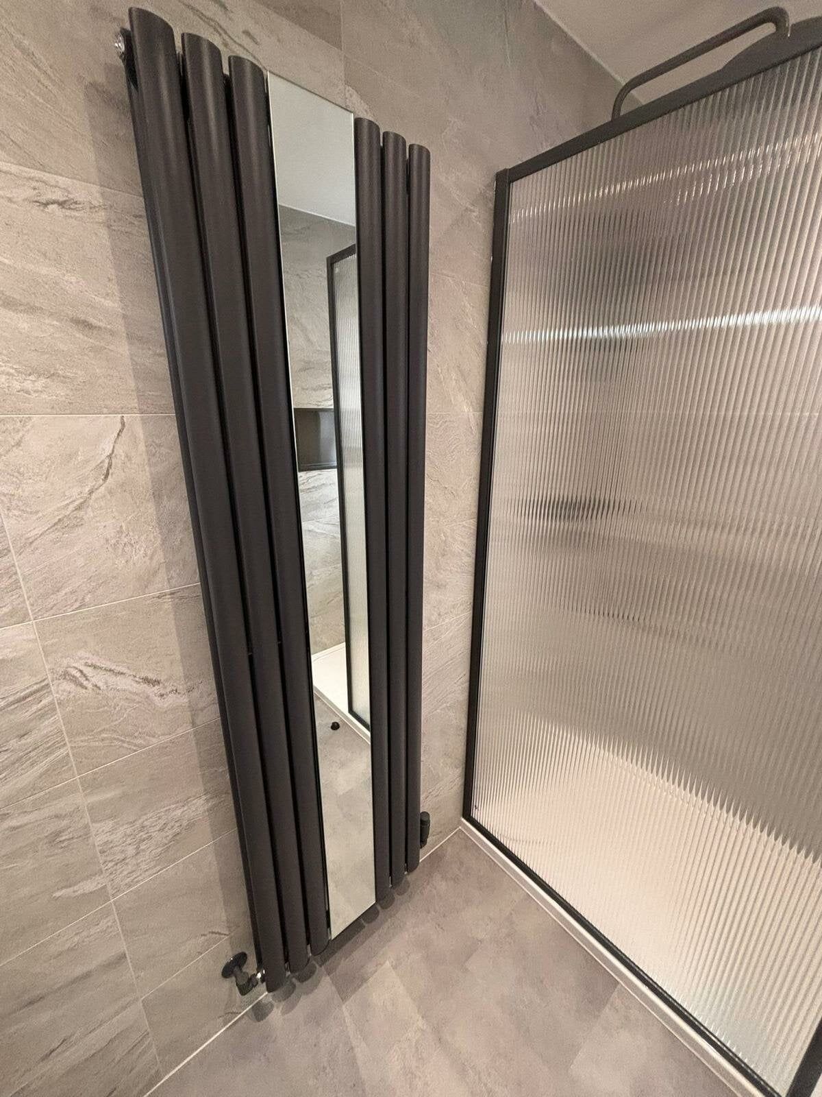 Designer radiator with mirror feature, shower screen with fluted glass and gunmetal brassware fixtures