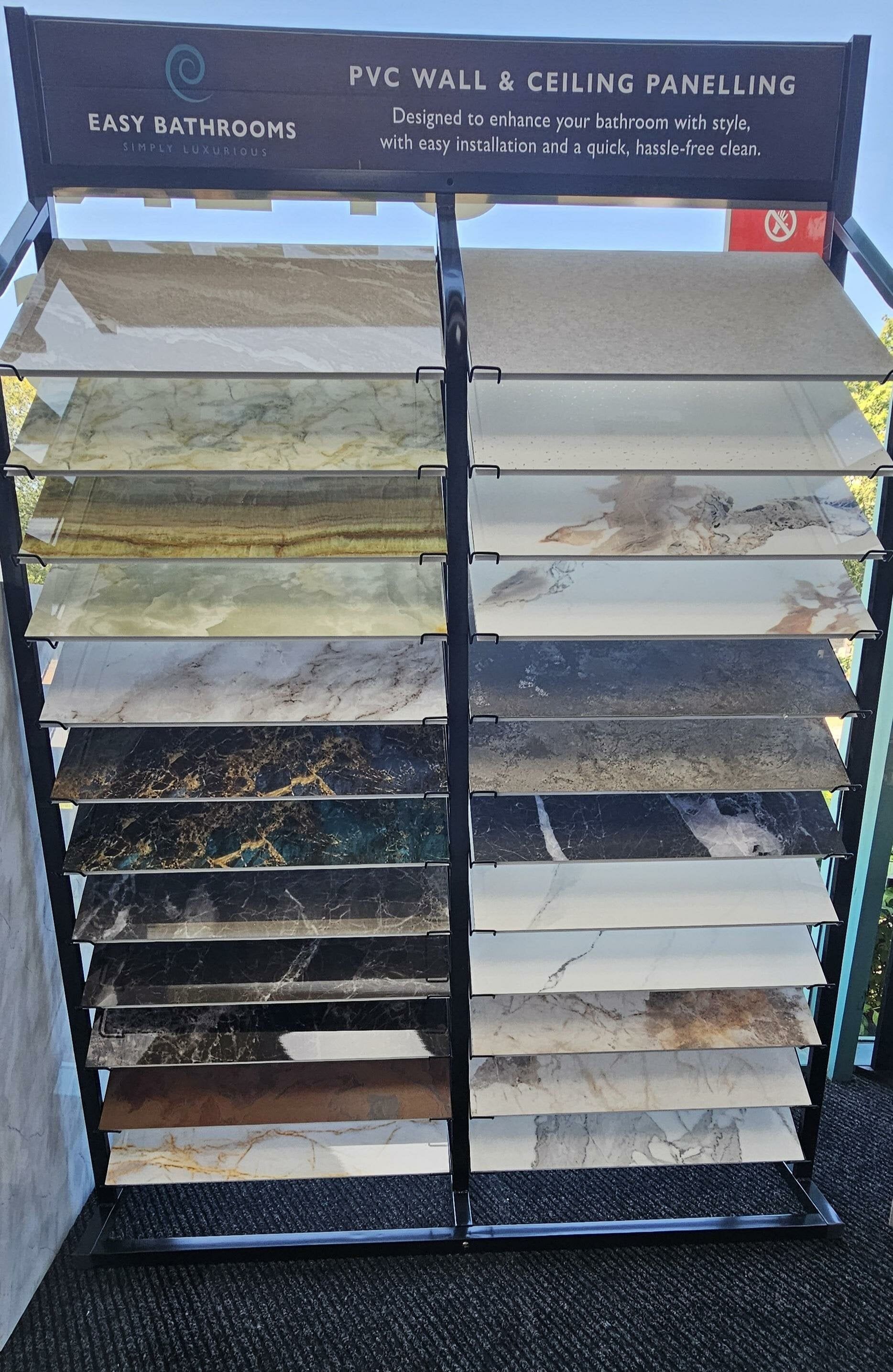 Pristina PVC bathroom wall panel sample display at Easy Bathrooms Crawley, showing a wide range of colours and finishes.