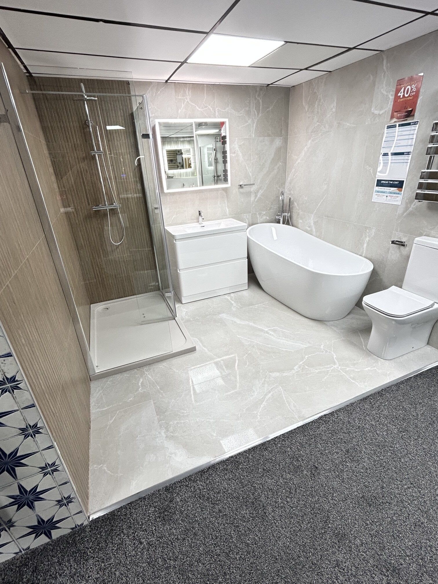 warm beige marble and wood slat tile display with walk in shower and freestanding bath