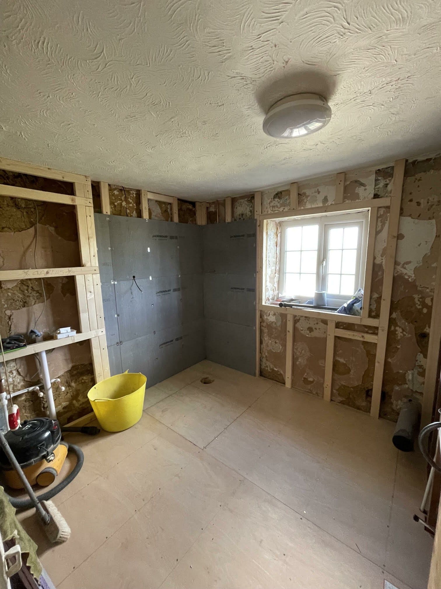 Bathroom during renovation with the previous fittings removed and the room stripped back.