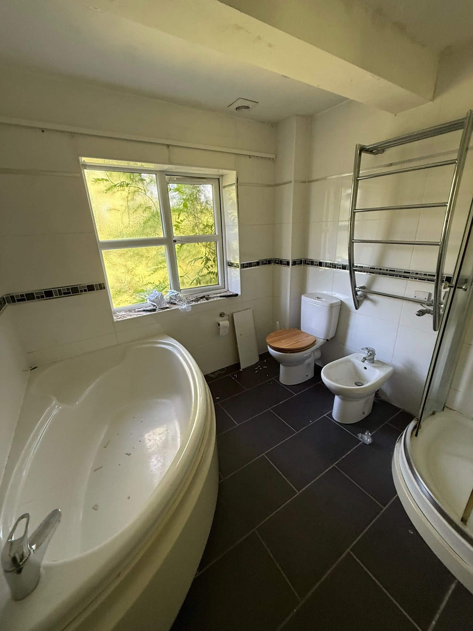Before photo of the bathroom showing the original freestanding bath and older room layout.