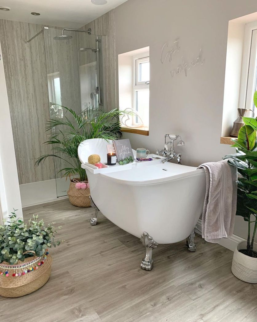 Traditional bathroom with a freestanding claw foot bath, chrome tap and warm wood-effect flooring.