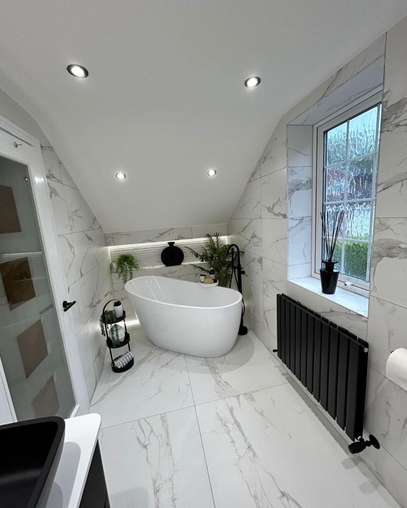 Isleworth slipper bath and Perth black radiator set against La Bella white marble porcelain in an attic bathroom.