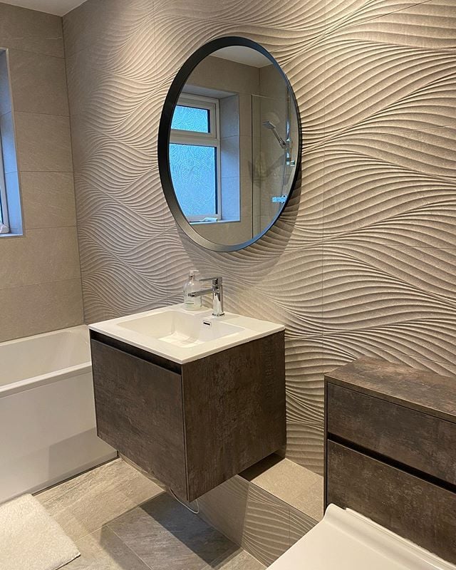 Modern bathroom with textured wave tiles, floating vanity unit, WC unit and soft neutral sand-toned finishes.
