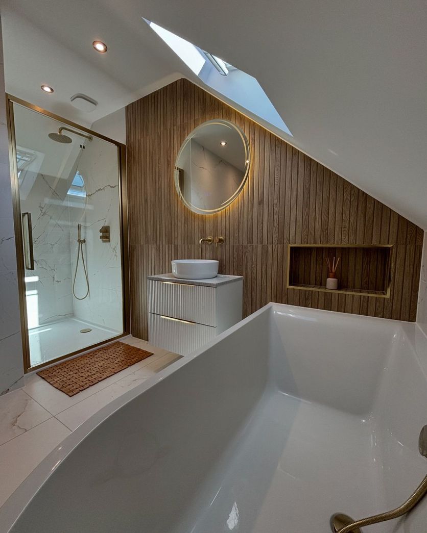 Dune 4D wood panel tiles and marble floor frame a white ribbed vanity, backlit mirror, and brushed gold shower.