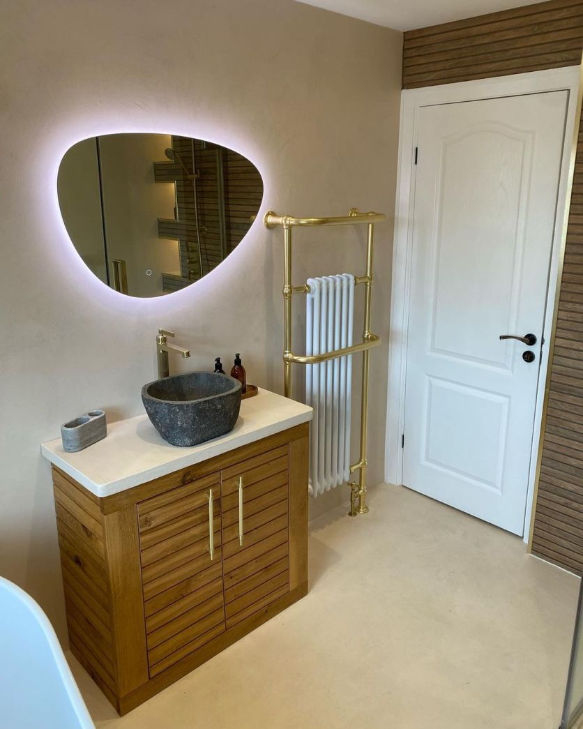 Ivy pebble mirror and Hive gold towel rail above a slatted vanity with a stone basin and Downton gold tap.