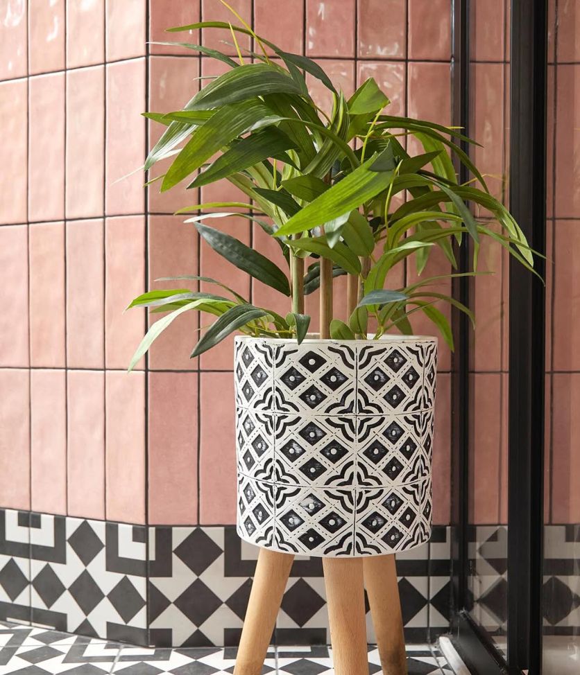 A detailed view of a modern eclectic bathroom featuring Napoli Rosa pink gloss brick tiles laid vertically, paired with Cascais Mix monochrome patterned porcelain floor tiles.
