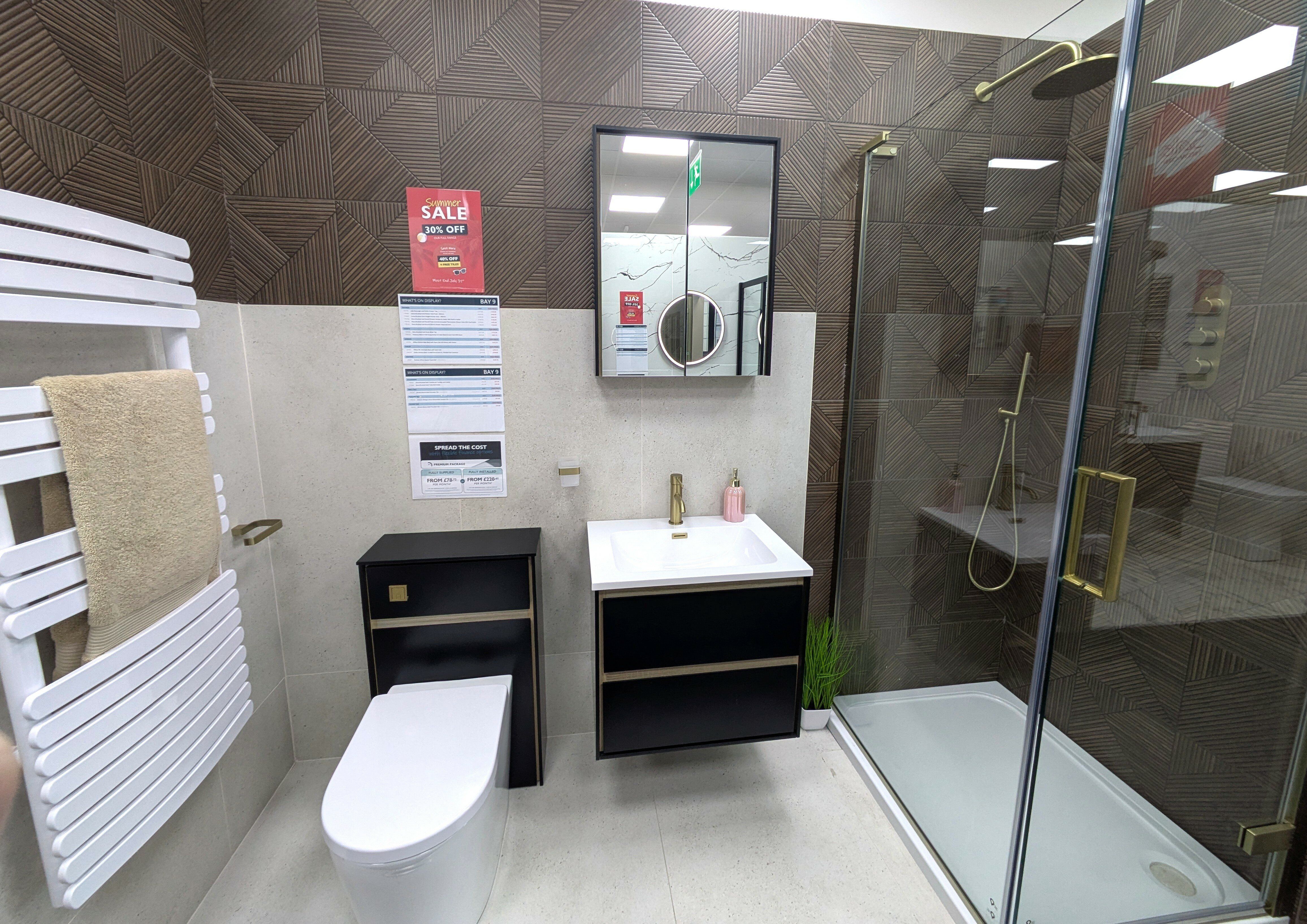 Modern bathroom display at Easy Bathrooms Lincoln with black furniture, wall-hung toilet and contrasting wood-effect tiles.