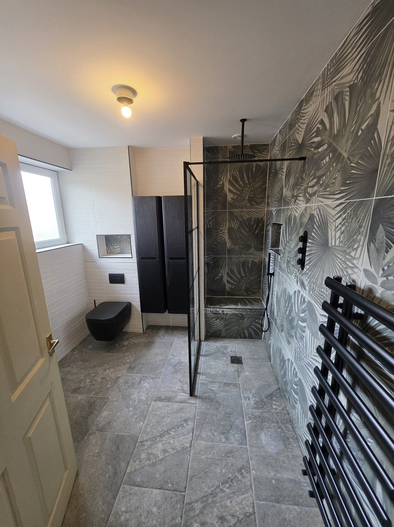 Completed accessible bathroom in Lincoln featuring a walk-in shower, modern grey tiles and clear floor space.