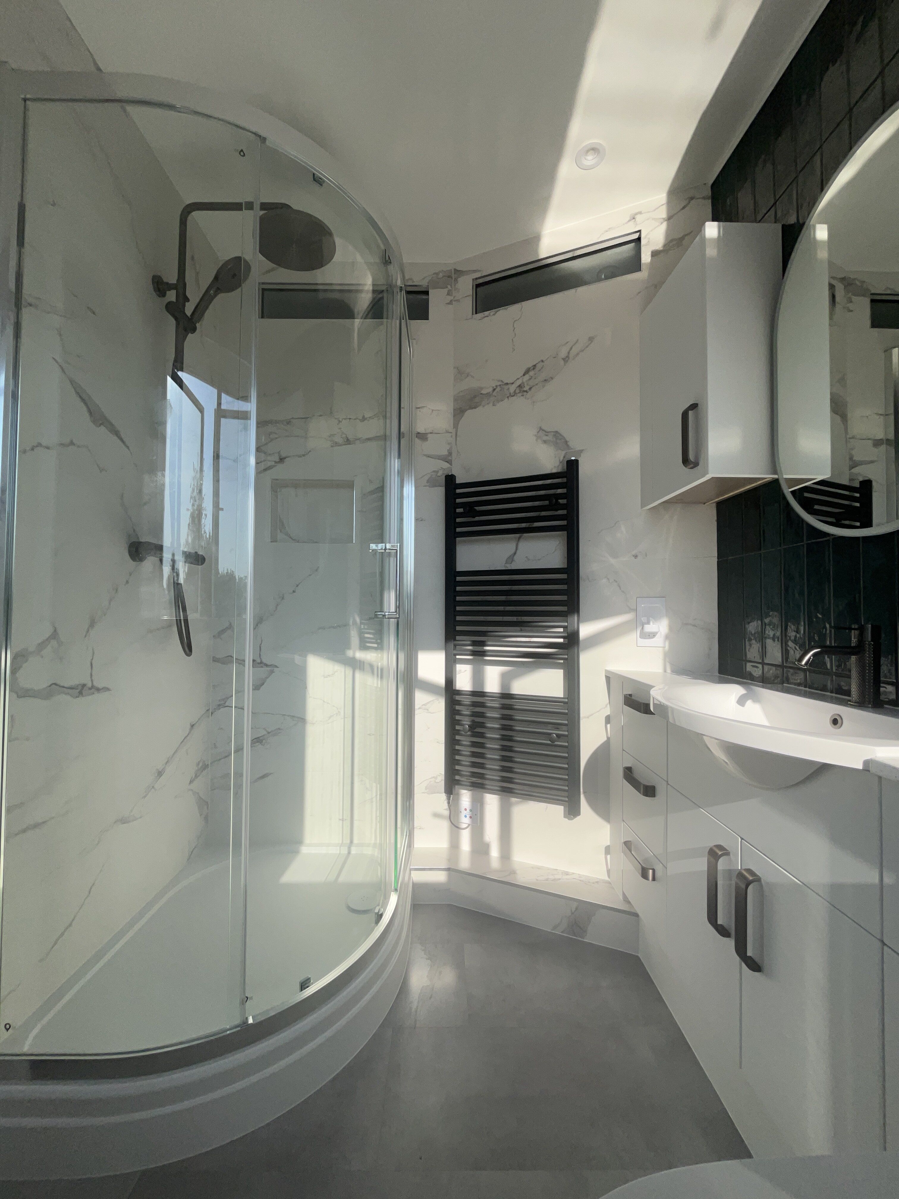 Customer bathroom transformation in Chichester with white furniture, integrated storage and modern neutral finishes.