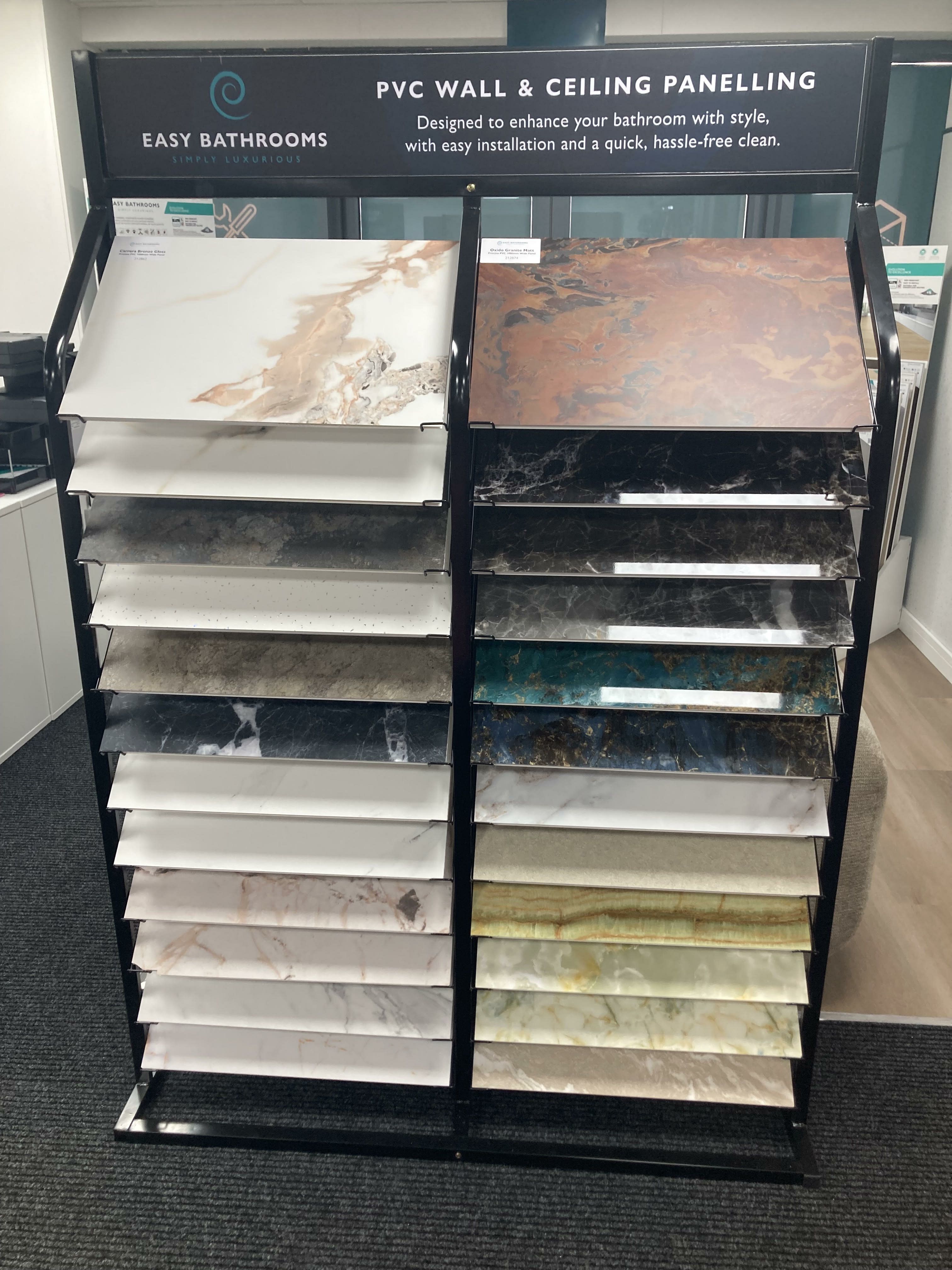 Bathroom wall panel sample stand showing a range of marble- and stone-effect finishes at Easy Bathrooms Shrewsbury.