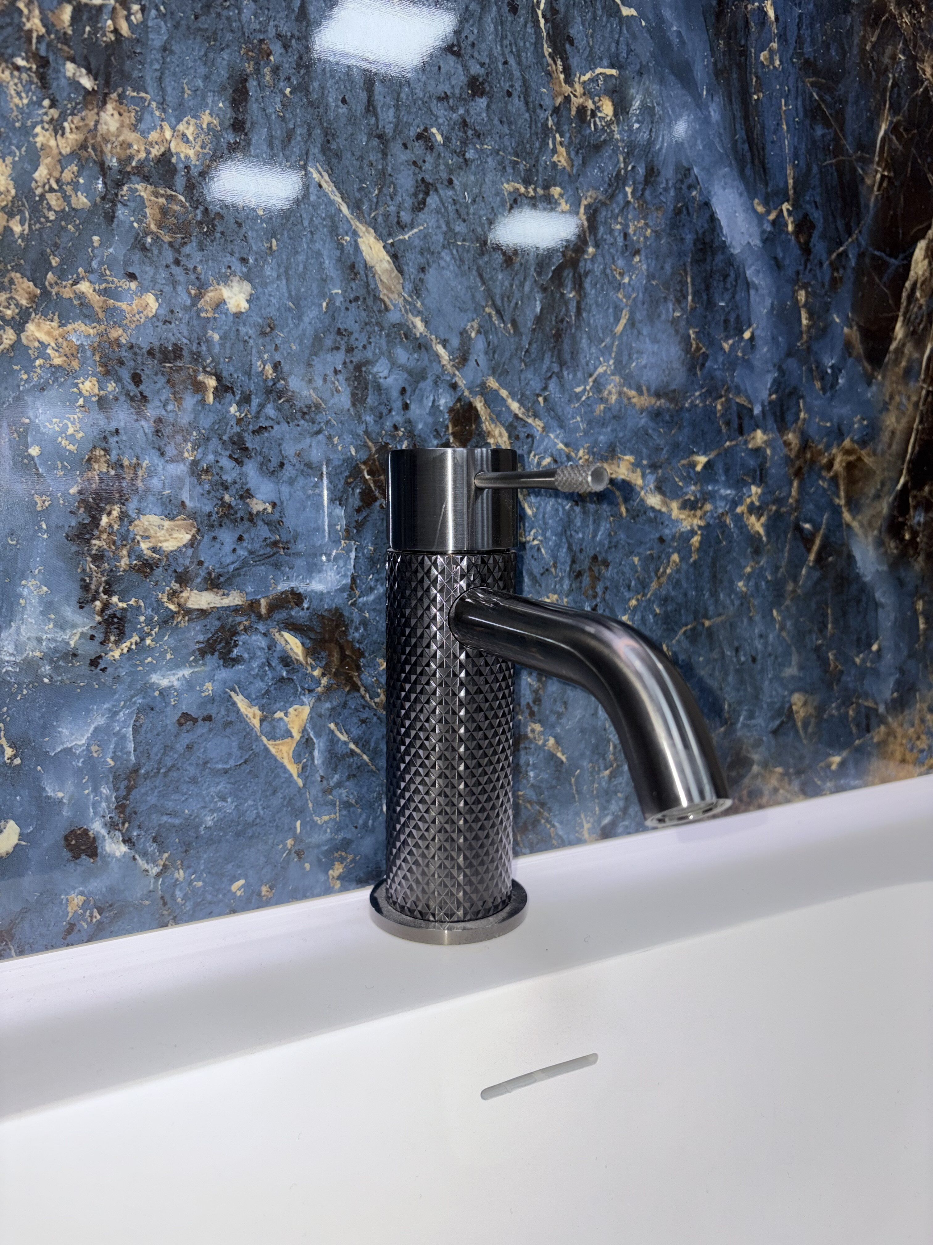 Dark blue marble-effect Pristina PVC wall panel shown with a modern bathroom tap at Easy Bathrooms Nottingham Castle.