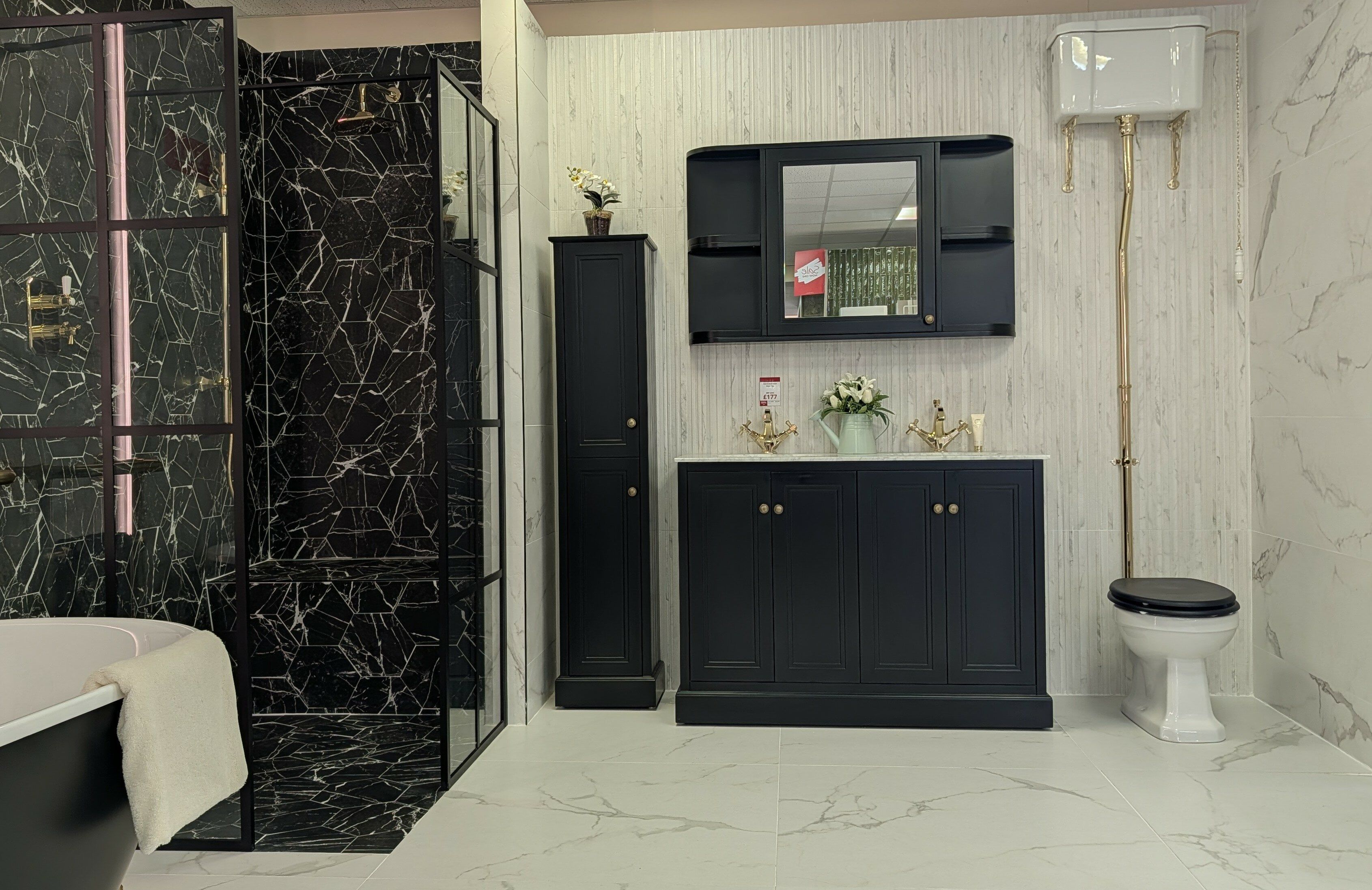 Traditional-style bathroom display at Easy Bathrooms Fareham with dark vanity furniture and patterned black tiles.