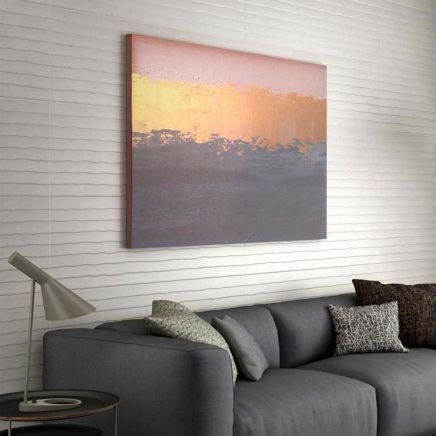Contemporary living room feature wall clad in Moonlight Blind Ceniza Ceramic Wall Tiles behind a dark grey sofa.