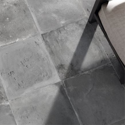 Floor layout of Fabrika Beton Concrete Square Porcelain Tiles 500x500mm next to an armchair.