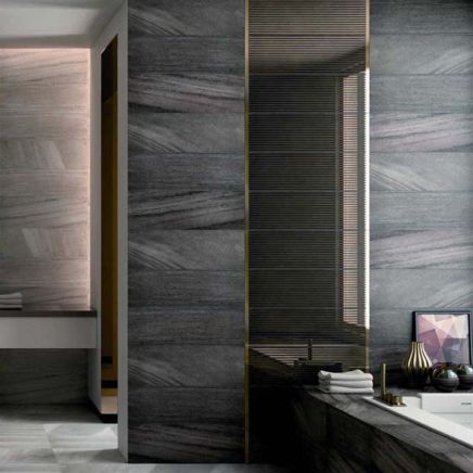 Luxurious dark bathroom roomset with walls tiled in Gabriel Anthracite 250x750mm ceramic tiles and warm brass accents