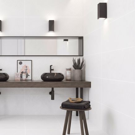 Modern spa-style bathroom with feature wall tiled in Kenya Axiom Blanco 400x1200mm 3D fan tiles behind twin black vessel sinks.