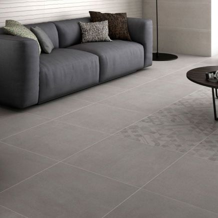 Modern living room floor tiled in Moonlight Grey Ceramic Floor Tiles 600x600mm with a grey sofa.