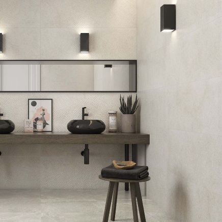 Modern spa-style bathroom tiled in Kenya Off White Matt Ceramic Wall Tiles with dark vessel sinks and wooden vanity.
