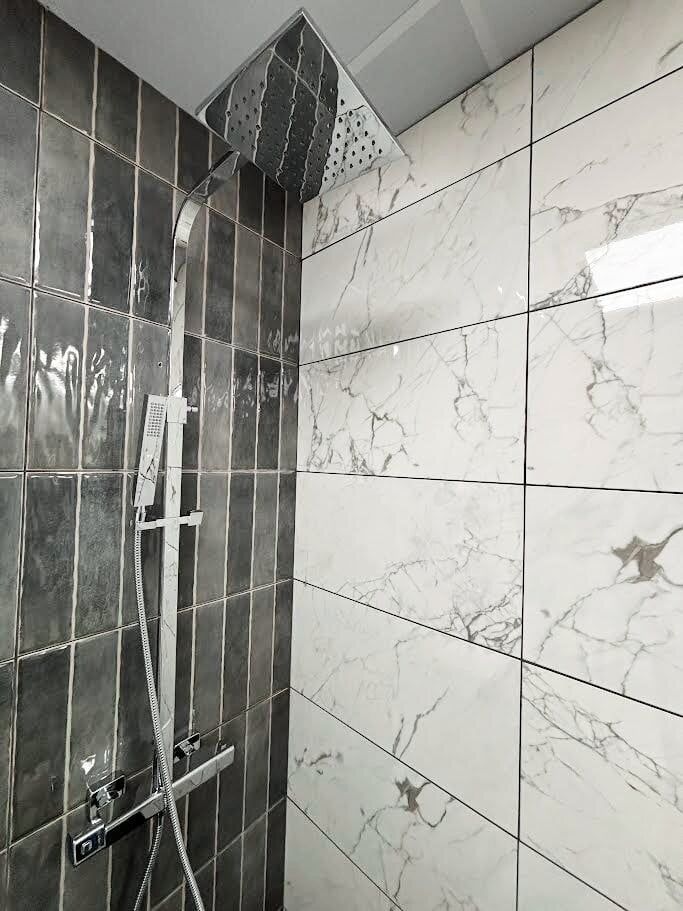 bathroom showroom display featuring chrome shower and contemporary tiles