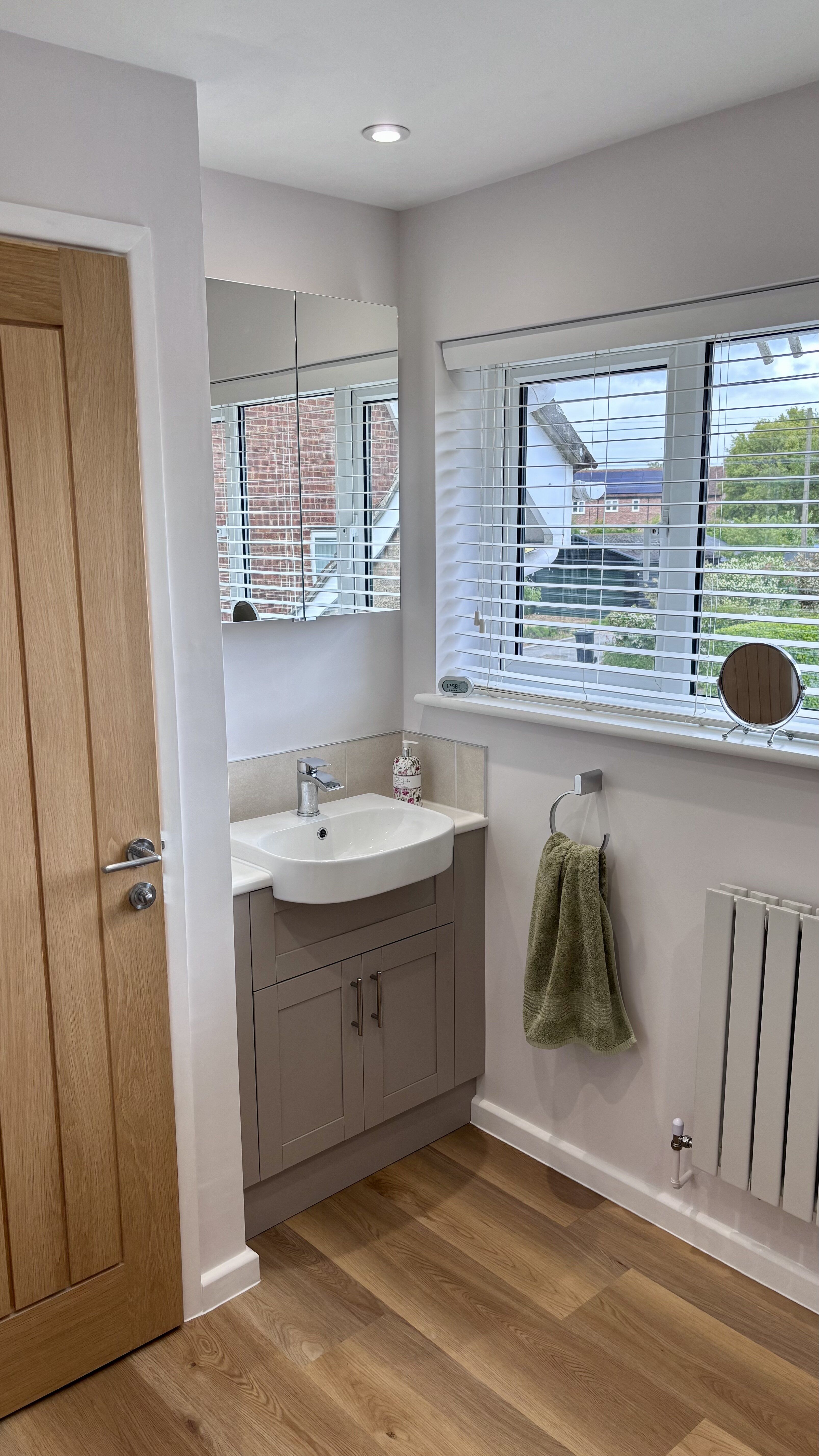 Bathroom display at Easy Bathrooms Ipswich featuring a freestanding bath, wall-hung toilet and warm wood-effect flooring.