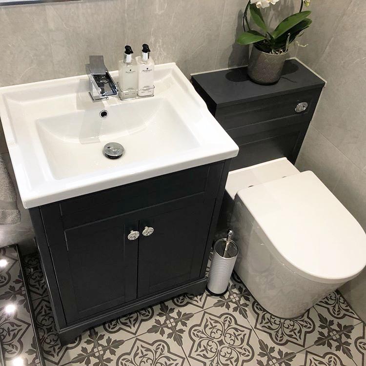 Traditional grey vanity and WC unit with patterned floor tiles in a compact bathroom.